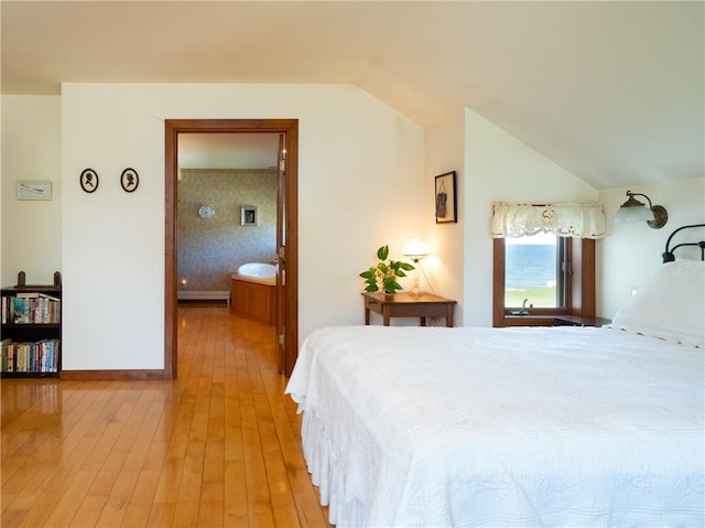 11037 Pratt Ln Unit 21, Yates, NY 14098 - bedroom featuring lofted ceiling, light wood finished floors, and ensuite bathroom