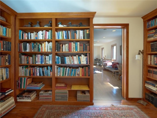 11037 Pratt Ln Unit 21, Yates, NY 14098 - sitting room with wall of books, wood finished floors, and recessed lighting