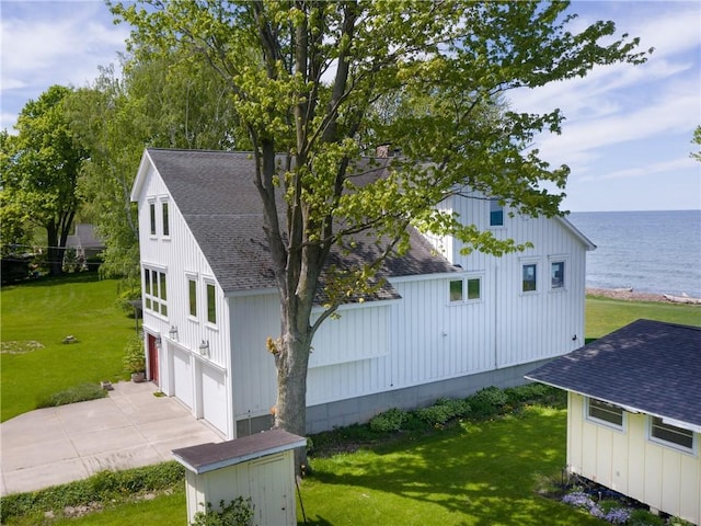 11037 Pratt Ln Unit 21, Yates, NY 14098 - view of property exterior featuring a shingled roof, a water view, driveway, a garage, and a lawn