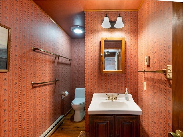 11037 Pratt Ln Unit 21, Yates, NY 14098 - half bathroom with wood finished floors, vanity, a baseboard heating unit, and wallpapered walls