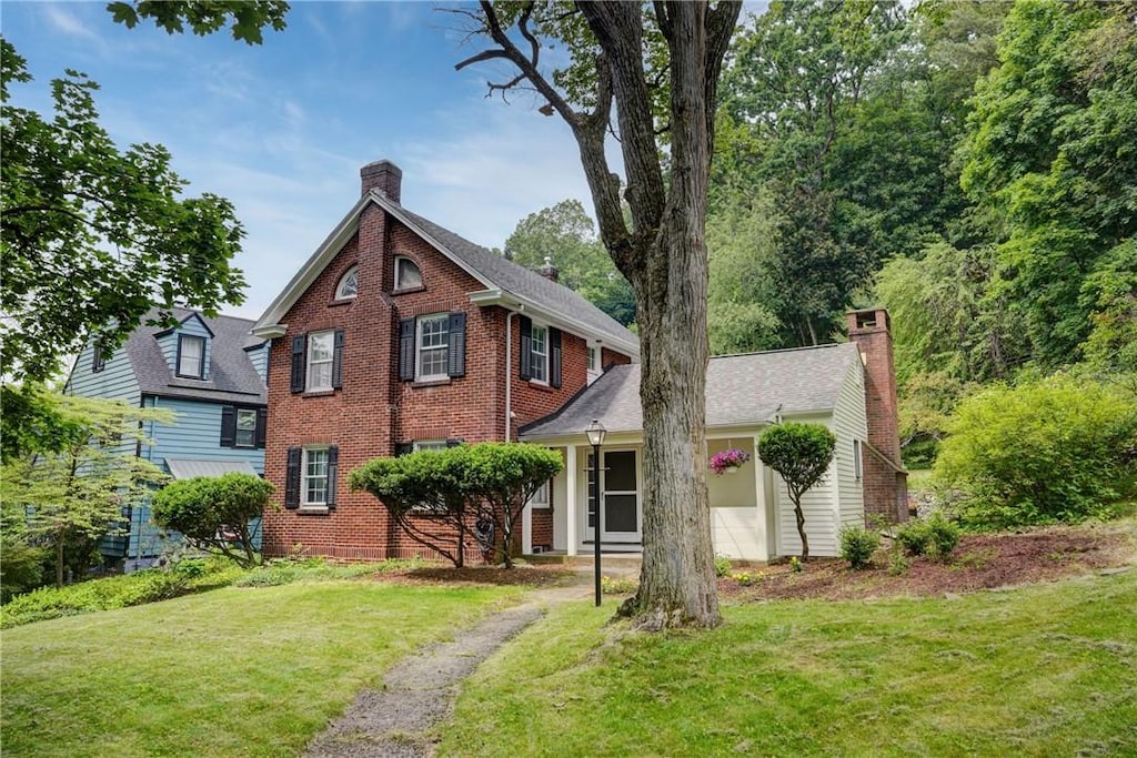 15 Nunda Blvd, Rochester, NY 14610 - view of front of home with a chimney, a front lawn, and brick siding