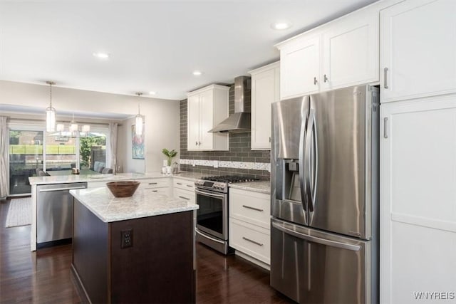61 Hidden Ridge Cmn, Amherst, NY 14221 - kitchen featuring stainless steel appliances, wall chimney exhaust hood, a peninsula, tasteful backsplash, and white cabinets