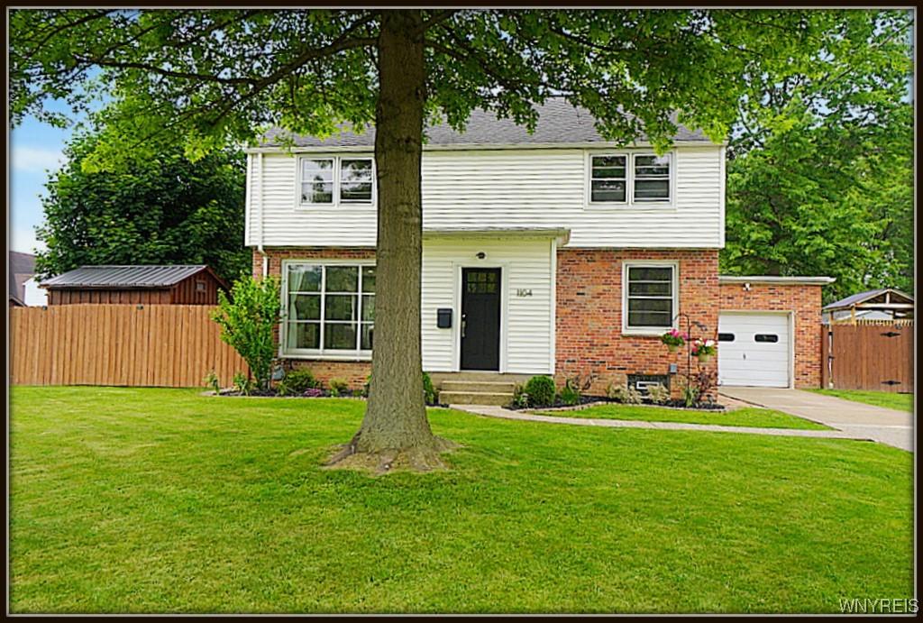 1104 Cayuga Dr, Niagara Falls, NY 14304 - colonial-style house featuring brick siding, driveway, and an attached garage