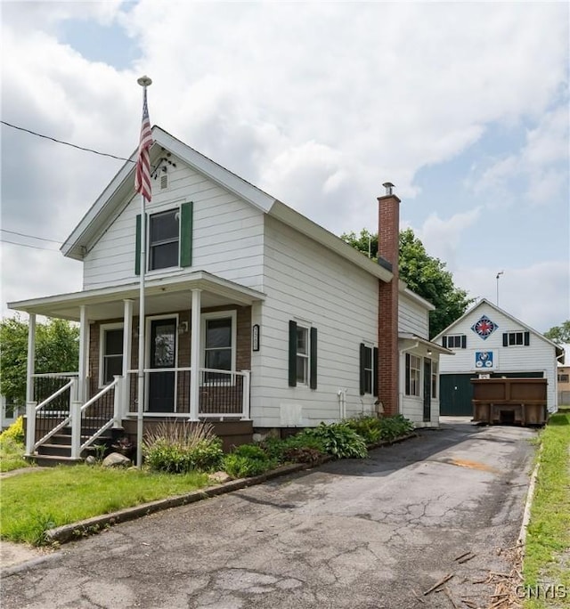 9569 Church St, Denmark, NY 13620 - view of front of home featuring a porch, a chimney, and a garage