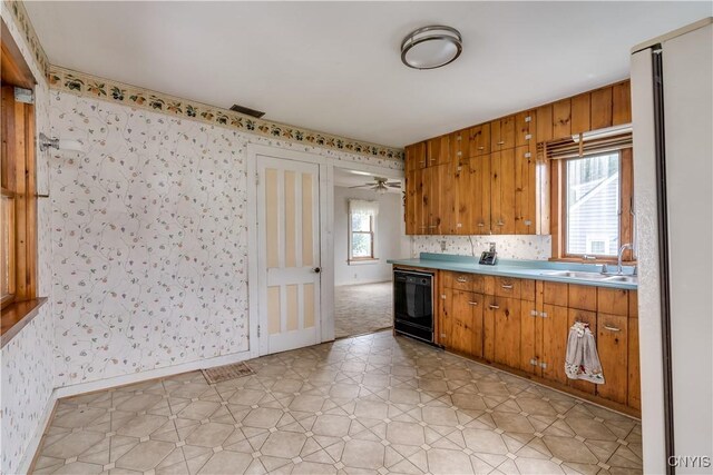 9569 Church St, Denmark, NY 13620 - kitchen with wallpapered walls, dishwasher, brown cabinets, light flooring, and refrigerator