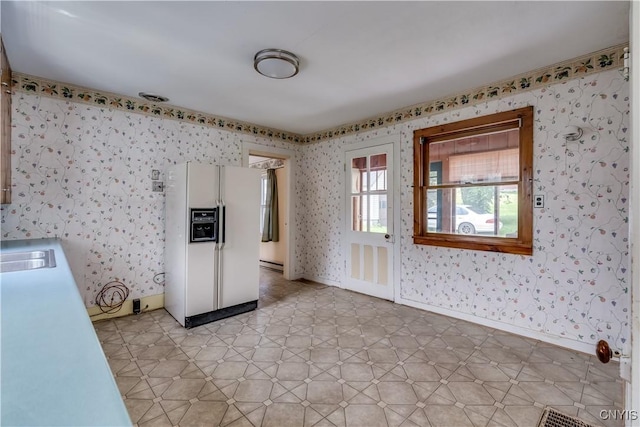 9569 Church St, Denmark, NY 13620 - kitchen featuring white refrigerator with ice dispenser, wallpapered walls, baseboard heating, and light flooring