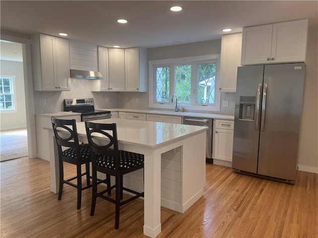 43 Harvest Rd, Perinton, NY 14450 - kitchen featuring appliances with stainless steel finishes, extractor fan, light countertops, light wood-style floors, and recessed lighting