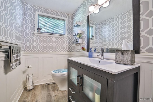 265 Miller Rd, Amherst, NY 14068 - bathroom featuring wallpapered walls, wood finished floors, vanity, and a wainscoted wall