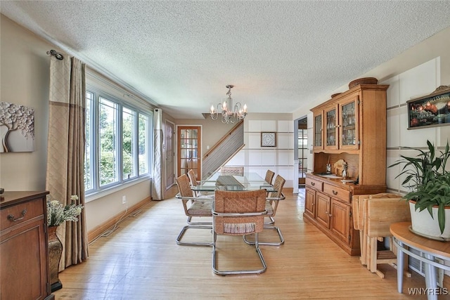 265 Miller Rd, Amherst, NY 14068 - dining area featuring a textured ceiling, a chandelier, light wood-style flooring, and stairs