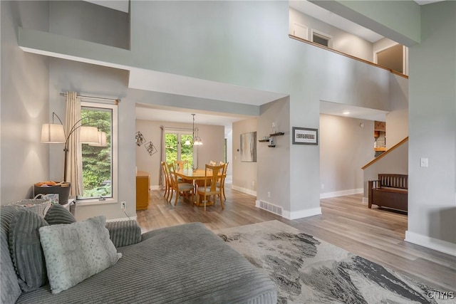 129 Quartz, Camillus, NY 13219 - living room with a high ceiling, wood finished floors, stairs, and a chandelier