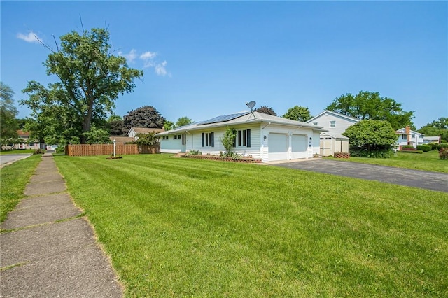 65 Meyerhill Cir E, Irondequoit, NY 14617 - view of front of house featuring roof mounted solar panels, driveway, and a garage