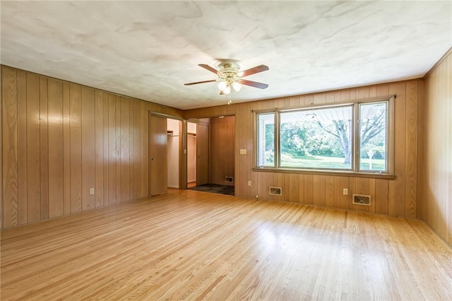 65 Meyerhill Cir E, Irondequoit, NY 14617 - empty room featuring wood finished floors, a ceiling fan, and wooden walls