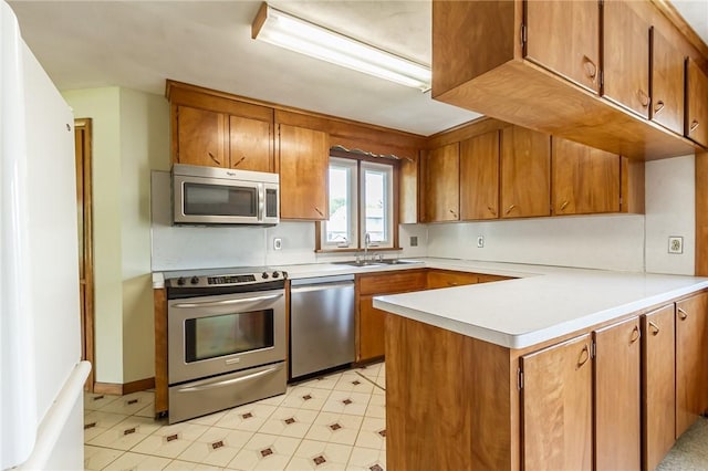 65 Meyerhill Cir E, Irondequoit, NY 14617 - kitchen with appliances with stainless steel finishes, a peninsula, brown cabinets, and light countertops