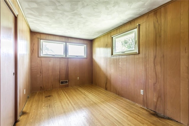 65 Meyerhill Cir E, Irondequoit, NY 14617 - spare room with light wood-style floors and wood walls