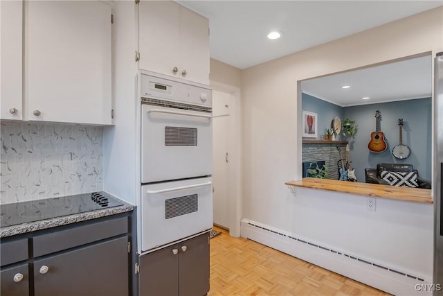 2304 Euclid Ave, Syracuse, NY 13224 - kitchen with a baseboard heating unit, white double oven, black electric stovetop, backsplash, and recessed lighting
