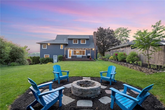 2304 Euclid Ave, Syracuse, NY 13224 - back of house at dusk with an outdoor living space with a fire pit