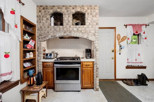 175 S Rondaxe Rd, Webb, NY 13420 - kitchen featuring stainless steel gas stove, light countertops, brown cabinets, open shelves, and backsplash