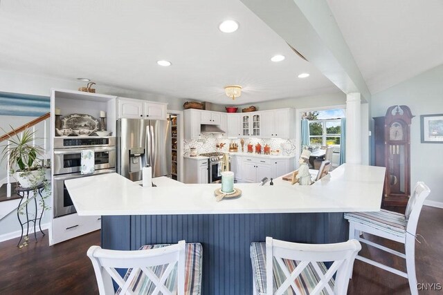 5479 Lake Rd, Tully, NY 13159 - kitchen featuring stainless steel appliances, white cabinetry, a kitchen bar, glass insert cabinets, and recessed lighting