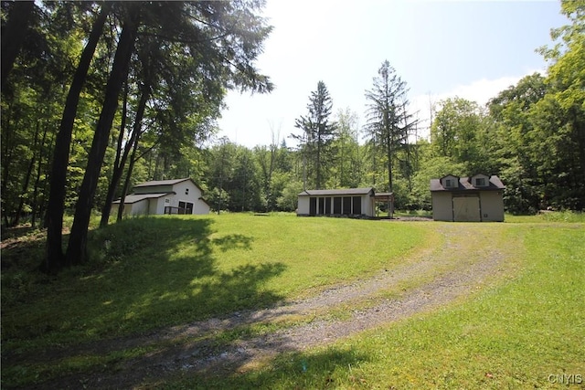 6234 Reservoir Rd, Lebanon, NY 13346 - view of green lawn with driveway, an outdoor structure, and a forest view
