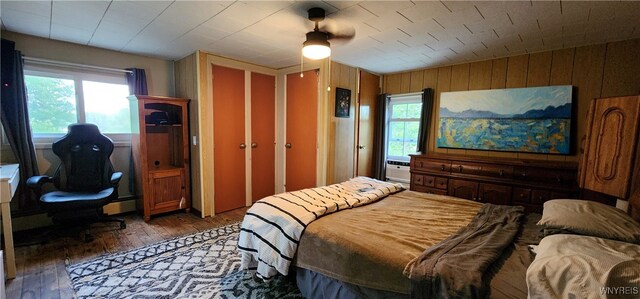 7029 Akron Rd, Lockport Town, NY 14094 - bedroom featuring wood-type flooring, wood walls, lofted ceiling, ceiling fan, and an office area