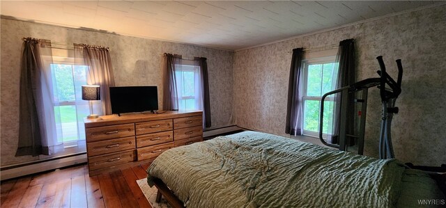 7029 Akron Rd, Lockport Town, NY 14094 - bedroom featuring hardwood / wood-style floors, a baseboard heating unit, ornamental molding, and wallpapered walls