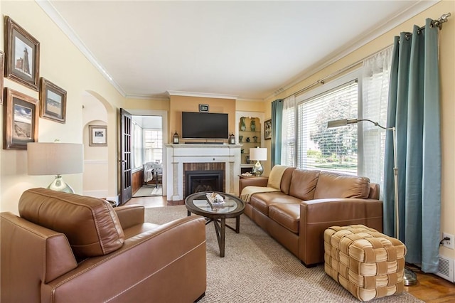 207 Wimbledon Rd, Irondequoit, NY 14617 - living room with ornamental molding, plenty of natural light, arched walkways, and a brick fireplace