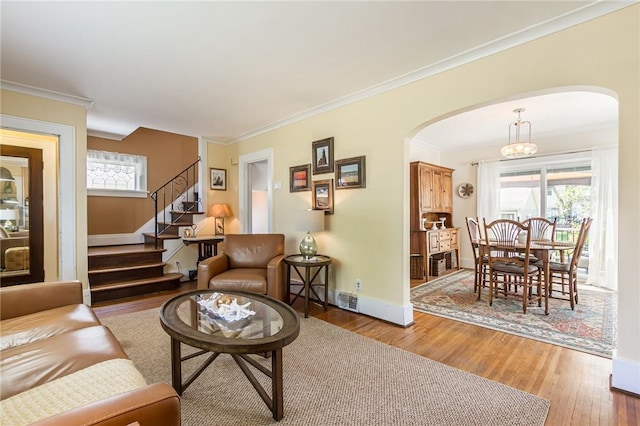 207 Wimbledon Rd, Irondequoit, NY 14617 - living room with arched walkways, light wood-type flooring, stairway, healthy amount of natural light, and crown molding