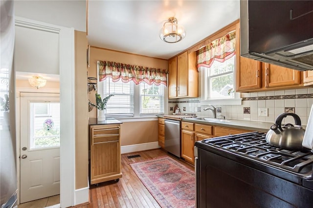 207 Wimbledon Rd, Irondequoit, NY 14617 - kitchen with dishwasher, black range with gas cooktop, light wood-style floors, ventilation hood, and tasteful backsplash