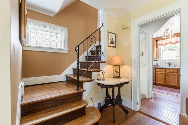 207 Wimbledon Rd, Irondequoit, NY 14617 - staircase featuring wood finished floors, crown molding, and a chandelier