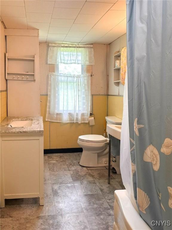9067 Main St, Brookfield, NY 13418 - full bathroom featuring vanity and tile walls