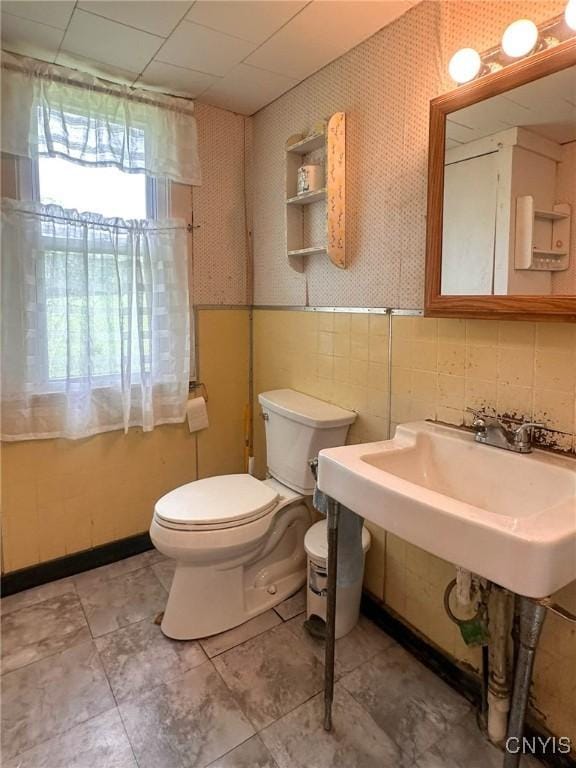9067 Main St, Brookfield, NY 13418 - half bathroom featuring wallpapered walls and a wainscoted wall