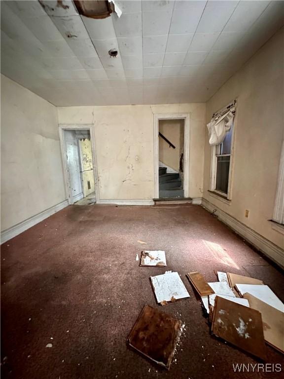 628 Elmwood Ave, Niagara Falls, NY 14301 - carpeted spare room featuring stairway and baseboards