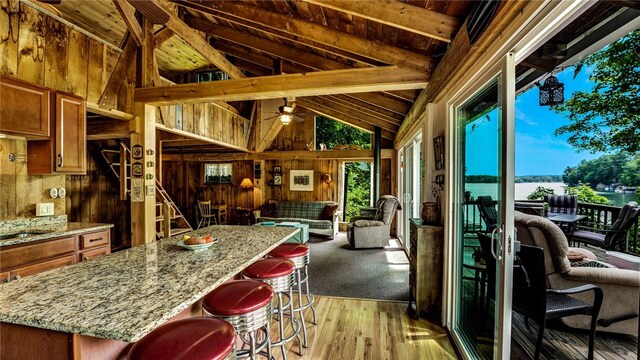 8567 Glen Rd, Rushford, NY 14777 - kitchen featuring wooden walls, brown cabinetry, healthy amount of natural light, light wood finished floors, and open floor plan