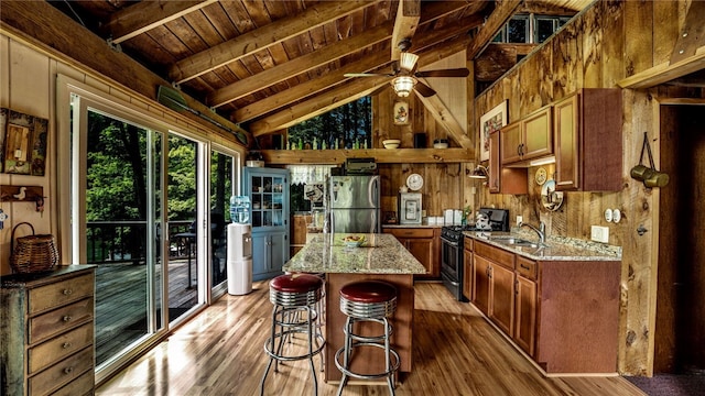 8567 Glen Rd, Rushford, NY 14777 - kitchen with stainless steel appliances, wooden ceiling, wood finished floors, wood walls, and brown cabinetry