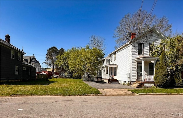 711 Stevens St, Utica, NY 13502 - view of side of home featuring a lawn, a residential view, and a chimney