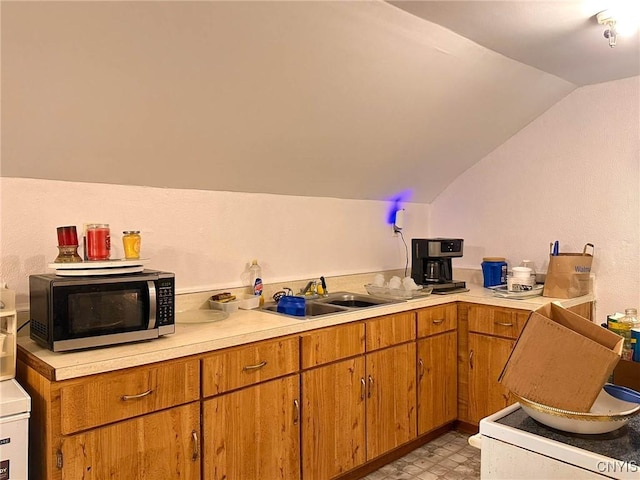 711 Stevens St, Utica, NY 13502 - kitchen with stainless steel microwave, light countertops, lofted ceiling, light floors, and brown cabinets