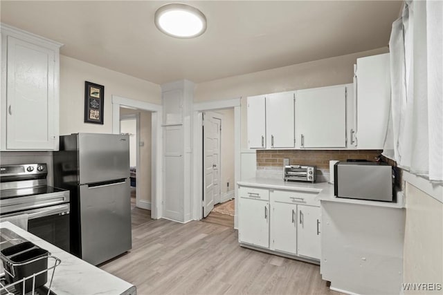 1812 18th St, Niagara Falls, NY 14305 - kitchen with appliances with stainless steel finishes, light countertops, white cabinets, and backsplash