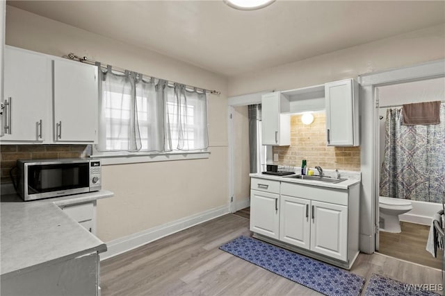 1812 18th St, Niagara Falls, NY 14305 - kitchen featuring stainless steel microwave, light countertops, white cabinetry, and tasteful backsplash