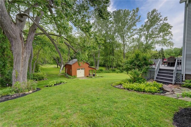 38 E Ave, Murray, NY 14470 - view of grassy yard with a wooden deck, an outdoor structure, a detached garage, and view of wooded area
