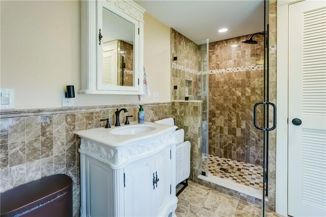 38 E Ave, Murray, NY 14470 - full bathroom featuring tile walls, a shower stall, vanity, a wainscoted wall, and recessed lighting