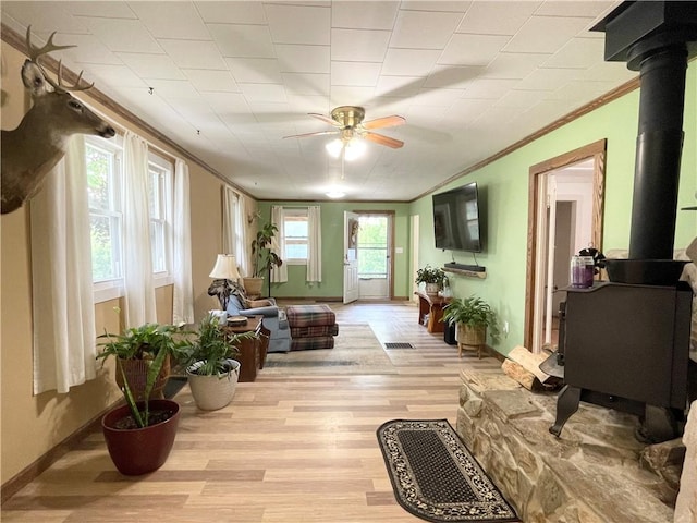 1663 Bingham Rd, Keating Town, PA 16726 - living area featuring a wood stove, crown molding, ceiling fan, and light wood finished floors