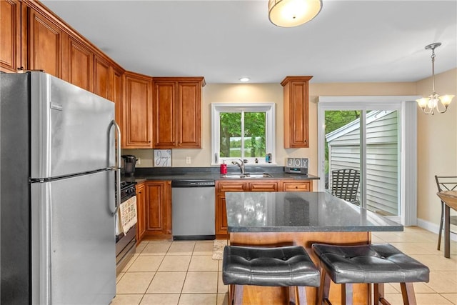 1617 Five Mile Line Rd, Penfield, NY 14526 - kitchen featuring stainless steel appliances, light tile patterned flooring, a chandelier, a kitchen bar, and a kitchen island