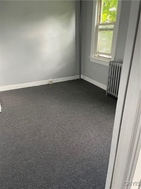 216 S 2nd St, Fulton, NY 13069 - empty room featuring radiator heating unit and dark carpet