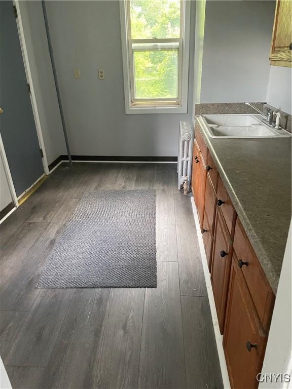 216 S 2nd St, Fulton, NY 13069 - kitchen with wood-type flooring, brown cabinets, and radiator heating unit