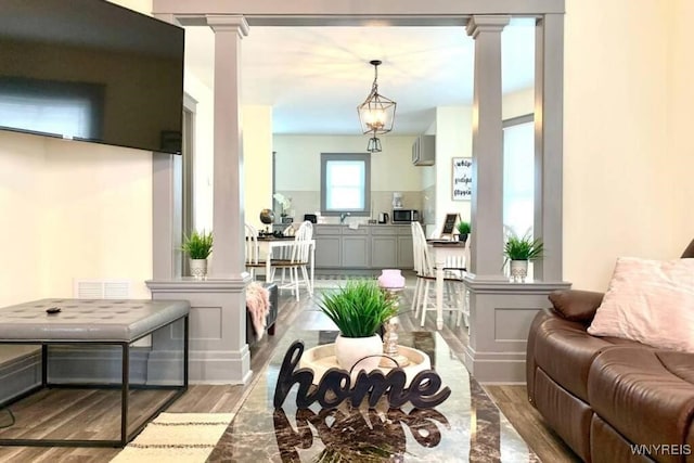 1008 Niagara Ave, Niagara Falls, NY 14305 - living room with decorative columns, wood finished floors, and an AC wall unit