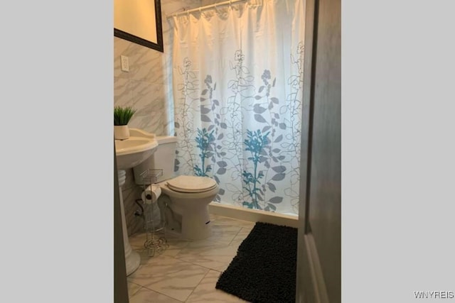 1008 Niagara Ave, Niagara Falls, NY 14305 - bathroom featuring a shower with curtain and marble look tile flooring