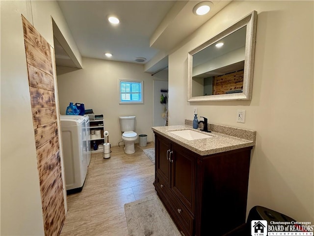 918 Crown St, Olean-City, NY 14760 - bathroom featuring washer / clothes dryer, vanity, wood finished floors, and recessed lighting
