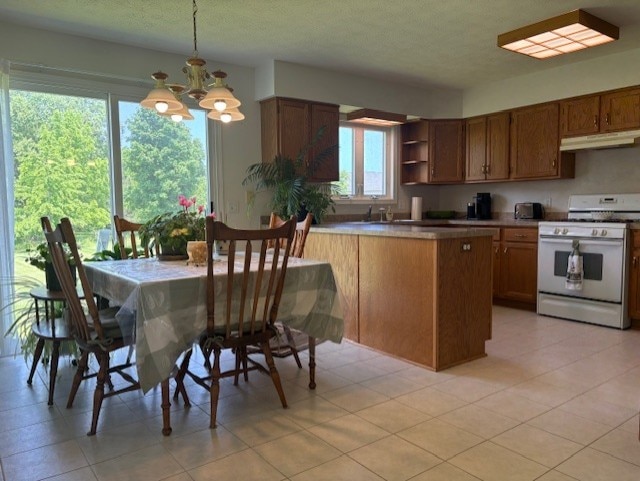 783 Whistlers Cove Ln, Greece, NY 14612 - kitchen with white gas stove, a peninsula, a chandelier, under cabinet range hood, and open shelves