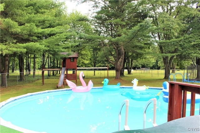 1808 Mulholland Rd, Vienna, NY 13123 - view of swimming pool featuring a playground, a trampoline, a fenced backyard, and view of wooded area