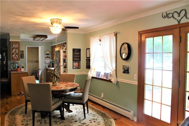 1808 Mulholland Rd, Vienna, NY 13123 - dining space featuring a baseboard radiator, wood finished floors, ceiling fan, and ornamental molding